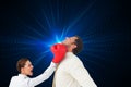 Businesswoman hitting a businessman with boxing gloves Royalty Free Stock Photo