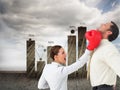 Businesswoman hitting a businessman with boxing gloves Royalty Free Stock Photo