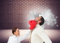 Businesswoman hitting a businessman with boxing gloves Royalty Free Stock Photo