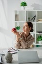 Businesswoman holding apple at workplace with Buddha head and laptop in office Royalty Free Stock Photo