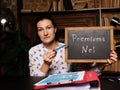 Businesswoman holding a black chalkboard. Business concept about Premiums Net with phrase on the sheet