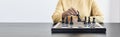 A businesswoman holding a black chess piece walks forward on a chessboard, comparing the chessboard to business administration.