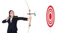 Businesswoman holding bow and shooting to archery target success