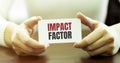 Businesswoman holding a card with text IMPACT FACTOR Royalty Free Stock Photo