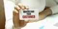 Businesswoman holding a card with text UNDERSTAND YOUR CUSTOMER