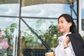 Businesswoman holding coffee outside office building. beautiful Royalty Free Stock Photo