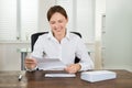 Businesswoman Holding Document At Desk
