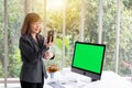 Businesswoman holding folders talking to mobile phone in front of computer Royalty Free Stock Photo