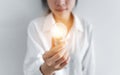 Businesswoman holding glowing light bulb, on white background Royalty Free Stock Photo