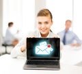 Businesswoman holding laptop with email sign