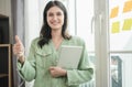 businesswoman holding laptop and showing thumbs up, Beautiful young woman using a tablet in the office Royalty Free Stock Photo