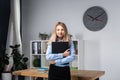 Businesswoman Holding Large File. young womanl standing in the office and holding folder. Portrait of young office worker holding Royalty Free Stock Photo