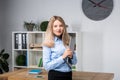 Businesswoman Holding Large File. young womanl standing in the office and holding folder. Portrait of young office worker holding Royalty Free Stock Photo