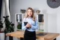 Businesswoman Holding Large File. young womanl standing in the office and holding folder. Portrait of young office worker holding Royalty Free Stock Photo