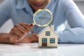 Businesswoman Holding Magnifying Glass Over House Model Royalty Free Stock Photo