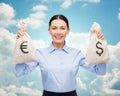 Businesswoman holding money bags with euro