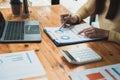 Businesswoman holding pen and pointing paper chart summary analyzing annual business report with using laptop computer Royalty Free Stock Photo