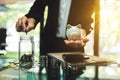 Businesswoman holding a piggy bank while putting coin into a glass jar Royalty Free Stock Photo