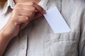 A businesswoman holding and putting a white blank business card into the shirt pocket Royalty Free Stock Photo