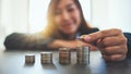 Businesswoman holding and stacking coins