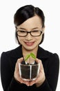 Businesswoman holding up a potted plant Royalty Free Stock Photo