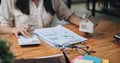 businesswoman with house model doing finances and calculate about cost to real estate investment and in other, tax Royalty Free Stock Photo