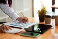 Businesswoman inspecting and checking the business reports graphs to audit the financial reports by calculating the Royalty Free Stock Photo