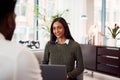 Businesswoman Interviewing Male Job Candidate In Seating Area Of Modern Office Royalty Free Stock Photo