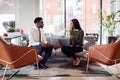 Businesswoman Interviewing Male Job Candidate In Seating Area Of Modern Office Royalty Free Stock Photo