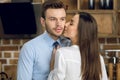 Businesswoman kissing businessman at home