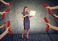 Beautiful businesswoman with laptop surrounded by many hands with phone headsets Royalty Free Stock Photo