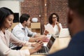 Businesswoman Leading Office Meeting Of Colleagues Sitting Around Table