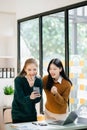 Businesswoman leading team meeting and using tablet and laptop computer with financial in coworking office