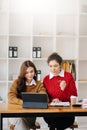 Businesswoman leading team meeting and using tablet and laptop computer with financial in coworking office