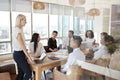 Businesswoman Leads Meeting Around Table Shot Through Door Royalty Free Stock Photo