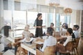 Businesswoman Leads Meeting Around Table Shot Through Door Royalty Free Stock Photo