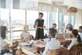 Businesswoman Leads Meeting Around Table Shot Through Door Royalty Free Stock Photo