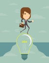 Businesswoman on a lightbulb cross an abyss. Royalty Free Stock Photo