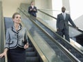 Businesswoman Looking Away While Moving Down On Escalator
