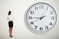 Businesswoman looking at big white clock Royalty Free Stock Photo