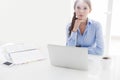 Businesswoman looking bored in front of laptop and television