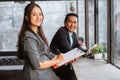 businesswoman looking at camera smiling with her partner in the background Royalty Free Stock Photo