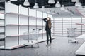 Businesswoman looking on empty retail shelves