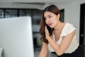 A businesswoman is looking at her computer screen with a serious face, talking on the phone Royalty Free Stock Photo