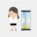 Businesswoman is looking at hourglass with Gold coins. Time is money. Royalty Free Stock Photo