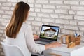 Businesswoman Looking At House On Laptop