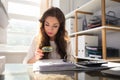 Businesswoman Looking At Invoice Through Magnifying Glass Royalty Free Stock Photo