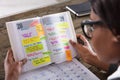 Businesswoman Looking At List Of Business Work In Diary