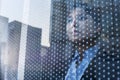 Businesswoman looking out through window, reflection of the city on the glass