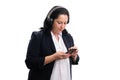 Businesswoman looking at phone listening to music in headphones Royalty Free Stock Photo